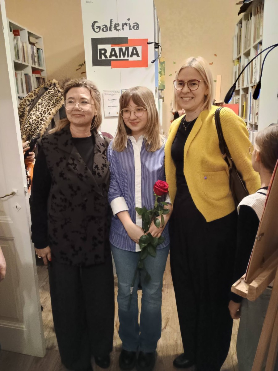 zdjęcie, spotkanie w bibliotece, uczestnicy spotkania, w tle regały z książkami