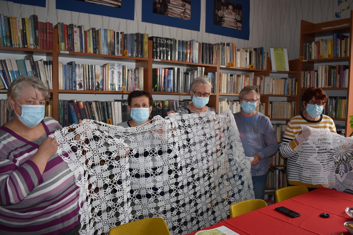 Powiększ obraz: kobiety, w tle regały z książkami, serwety zrobione na szydełku